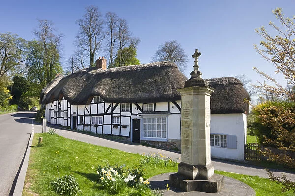 Thatched cottages and war memorial in the village of Wherwell, Hampshire, England