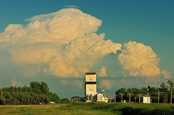 Thunderhead (cumulonimbus) clouds of approaching storm and grain elevator Dufresne, Manitoba, Canada