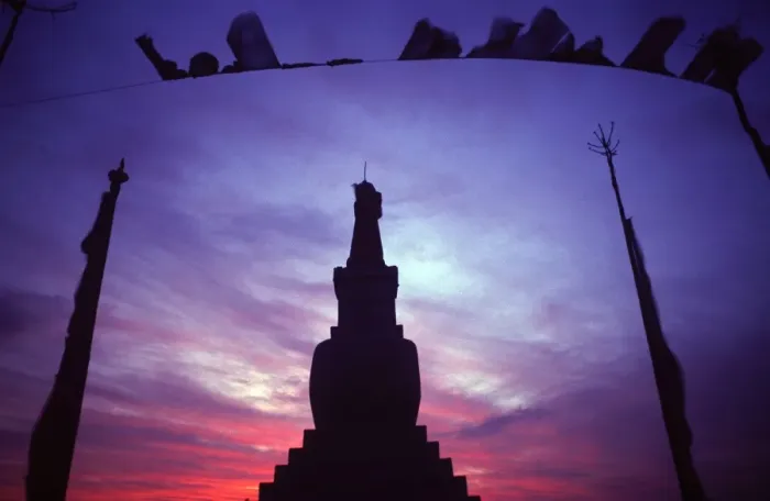 Framed Print : Tibetan Buddhist stupa and prayer flags silhouetted against sunset Framed Print : Tibetan Buddhist stupa and prayer flags silhouetted against sunset
