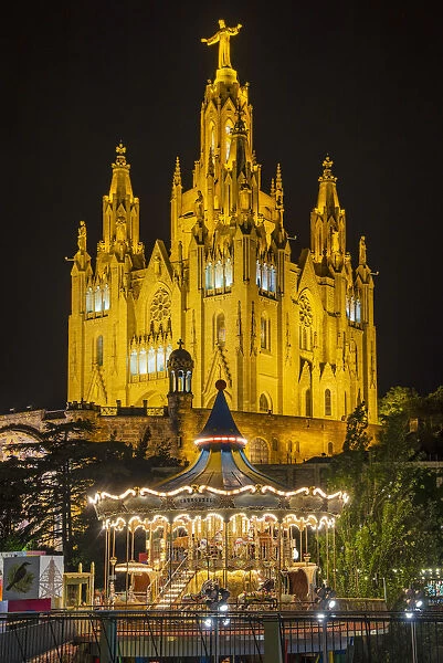 Tibidabo amusement park by night with Temple de Sagrat Cor behind, Barcelona, Catalonia