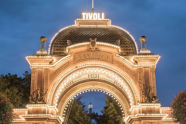 Tivoli gardens, Copenhagen, Hovedstaden, Denmark. The entrance illuminated at dusk