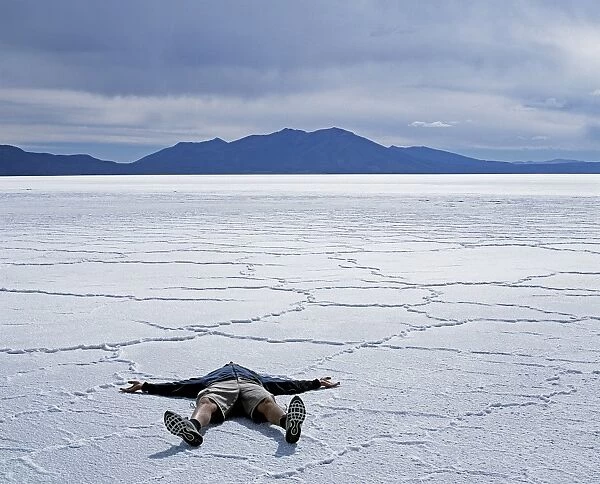 A tourist lies on the salt crust of the Salar de Uyuni