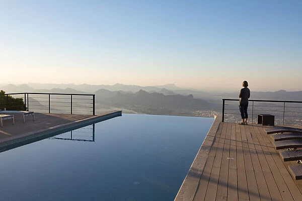 A tourist looks out at the view from the swimming pool at The View hotel, Al Hamra, Oman