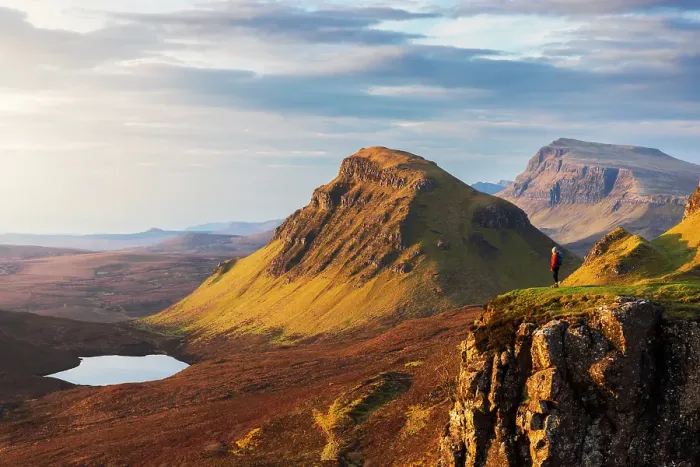 Framed Print : A tourist observes mountains from Quiraing viewpoint during sunrise, Isle of Skye, Inner Hebrides, Highlands, Scotland, United Kingdom (MR)