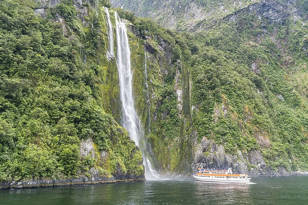 Touristic boat facing Stirling Falls in Milford Sound. Fiordland NP, Southland district