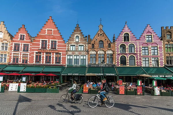 Tourists biking in Markt or Market Square, Bruges, West Flanders, Belgium