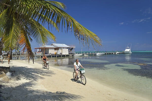 Tourists enjoying a bike ride along the beach at San Pedro, Ambergris Caye, Caribbean