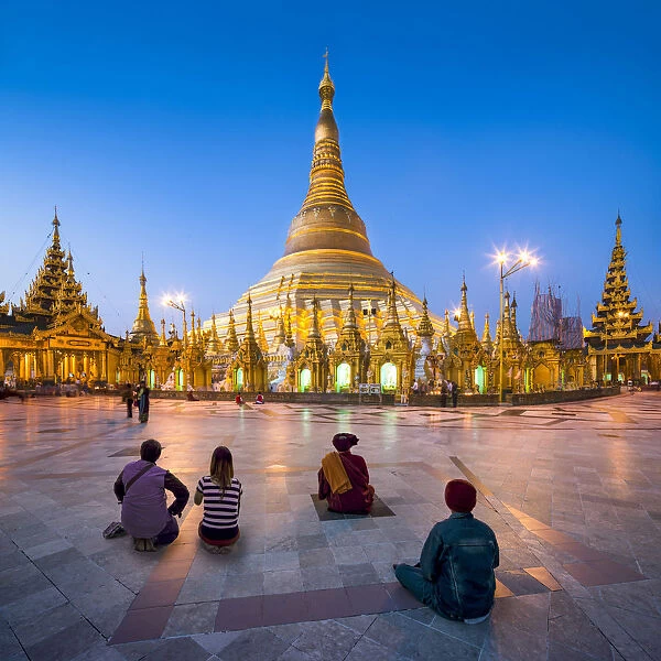 Tourists praying at the Shwedagon Pagoda in Yangon, Yangon Region, Myanmar