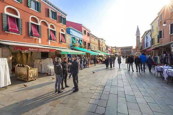 Tourists shopping, colorful stores and restaurants in Via Baldasarre Galuppi, Burano