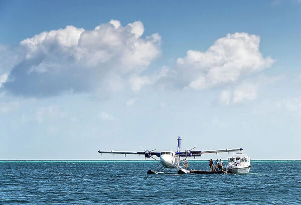 Tourists transfer from a speed boat to a seaplane, Baa Atoll, Maldives