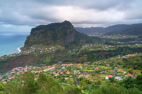 Town of Faial near mountains against cloudy sky, Santana, Madeira, Portugal