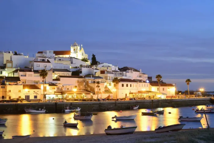 Framed Print : The traditional fishing village of Ferragudo at dusk, bordering the Arade river. Algarve