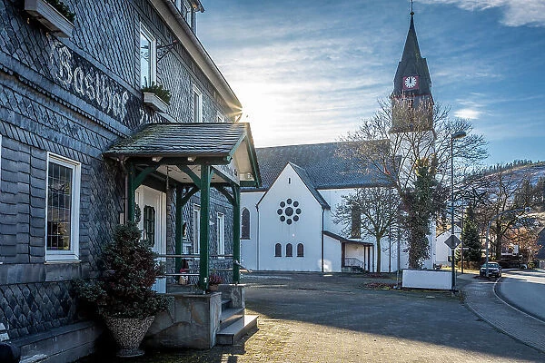 Traditional inn Hochheide and village church in Niedersfeld near Winterberg, Sauerland, North Rhine-Westphalia, Germany