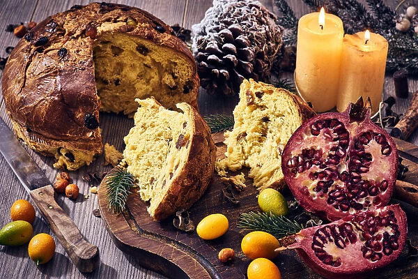 Traditional Italian Christmas cake with candles, pomegranate and winter fruits, panettone
