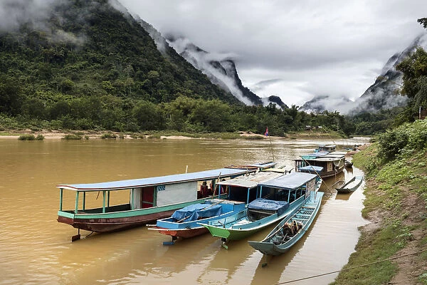 Traditional longboats moored up on Nam Ou river, Nong Khiaw, Luang Prabang Province