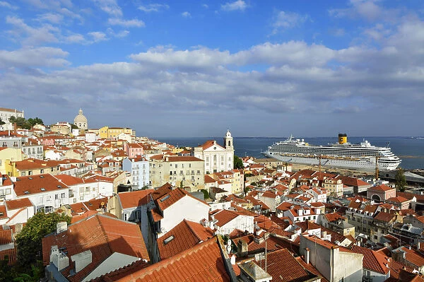 The traditional and moorish Alfama district and a cruise ship on the Tagus river. Lisbon