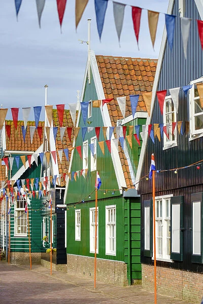 Traditional wooden houses decorated with flags of Dutch national colors for Koningsdag