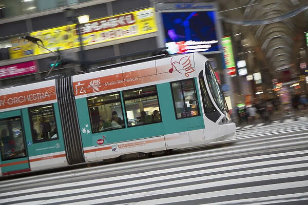 Tram passing along street, Hiroshima, Hiroshima Prefecture, Japan