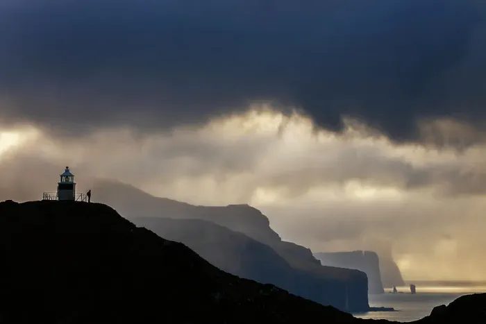 Framed Print : A trekker at Kallur lighthouse with a scenic view at sunset, Kalsoy, Faroe Islands, Denmark Framed Print : A trekker at Kallur lighthouse with a scenic view at sunset, Kalsoy, Faroe Islands, Denmark