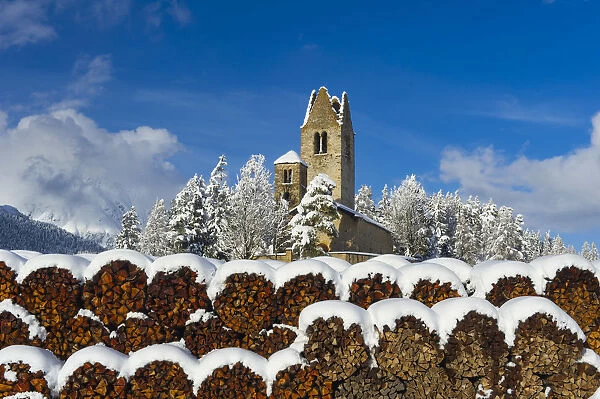 Trunks and old church in Celerina with pristine snow. Engadine, Switzerland, Europe