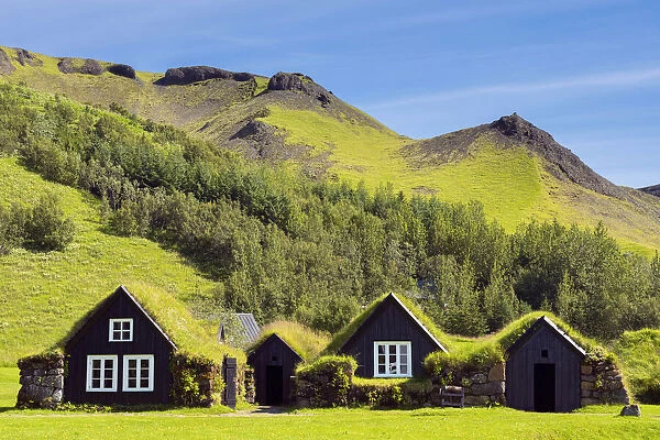 Turf roofed houses under mountain range at Skogar Museum, Skogar, Rangarping eystra, Southern Region, Iceland