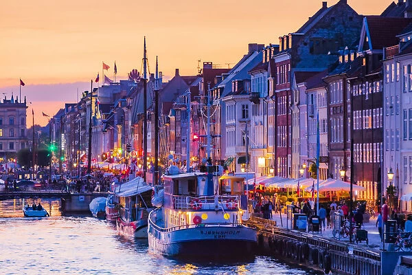 Typical buildings along Nyhavn water canal in Copenhagen at sunset, Denmark
