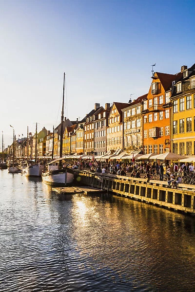 Typical buildings along Nyhavn water canal in Copenhagen at sunset, Denmark