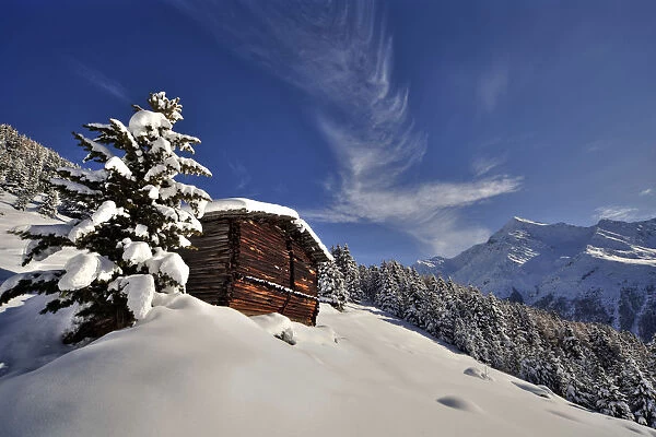 A typical mountain hut in Plazzanec over Santa Caterina Valfurva after a snowfall