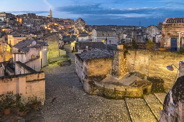 Typical paved alley in the old Sassi quarter at dusk. Matera, Basilicata region, Italy