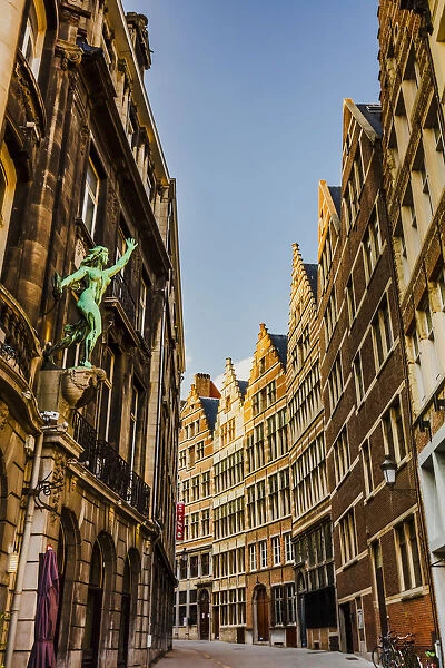 Typical road in Antwerp with old buildings and a statue, Belgium