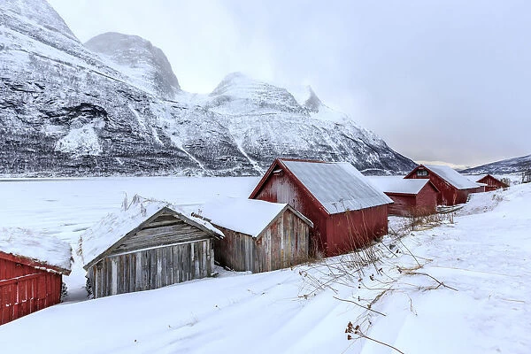 Typical wooden huts in the snowy landscape of Lyngseidet Lyngen Alps Tromsa¸ Lapland Norway Europe