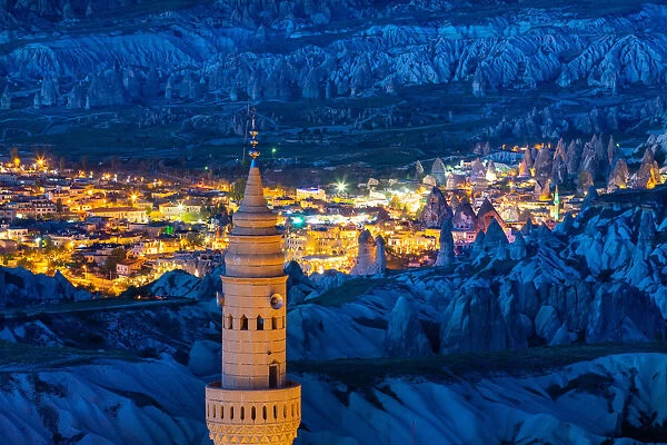 Uchisar minaret with Goreme town in the background at dusk