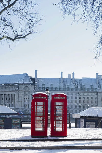 United Kingdom, England, London, red phone boxes on Victoria Embankment in the snow