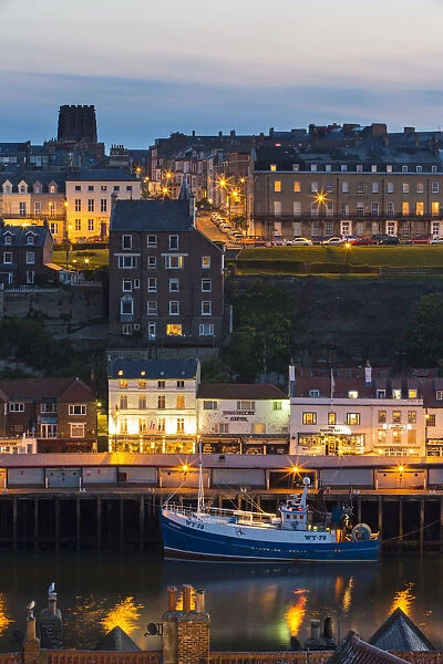 United Kingdom, England, North Yorkshire, Whitby. A view of the harbour at dusk