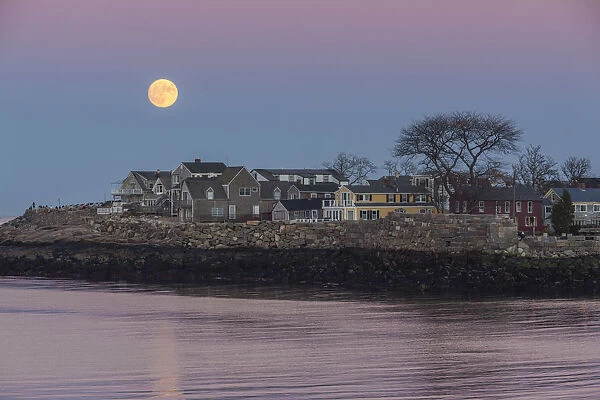 USA, Massachusetts, Cape Ann, Rockport, moonrise over buildings on Bearskin Neck, dusk