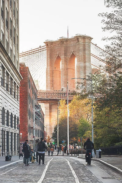 USA, New York City, People walking in Dumbo district (Brooklyn) with the Brooklyn bridge in the background
