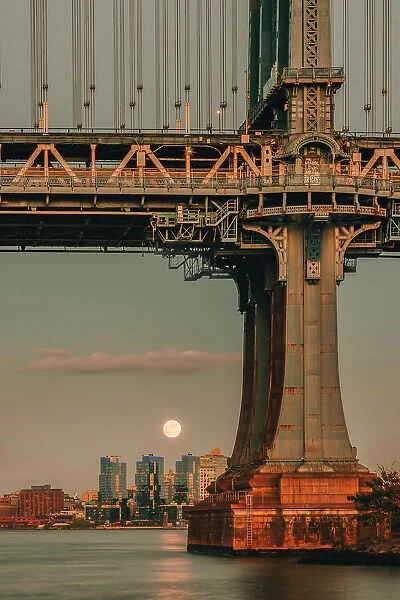 USA, New York City, view of the Moon rising behind the Manhattan Bridge