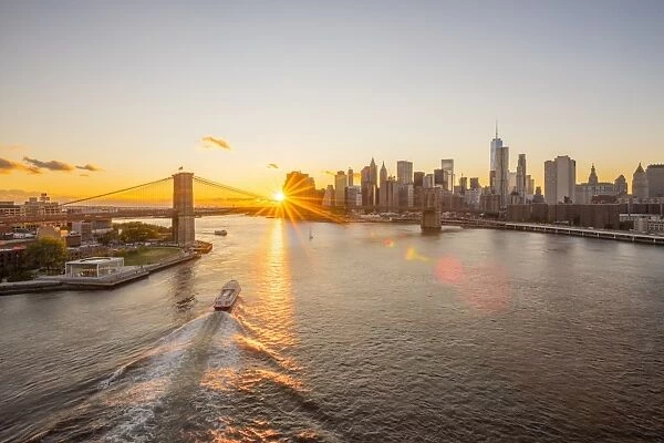 USA, New York, Lower Manhattan Skyline and Brooklyn Bridge over East River at Sunset