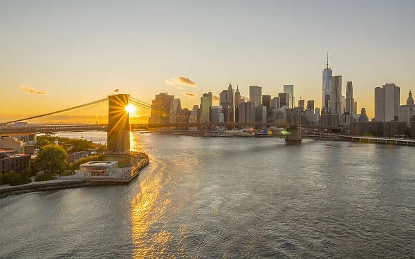 USA, New York, Lower Manhattan Skyline and Brooklyn Bridge over East River at Sunset