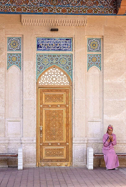 Uzbekistan, Samarkand, Hazrat Khizr Mosque, a young woman prays in the courtyard