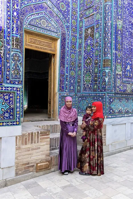 Framed Print : Uzbekistan, Samarkand, Shah-i-Zinda, Tomb Street of 11 Mausoleums, two young women with a baby stand in front of the entrance to a mausoleum