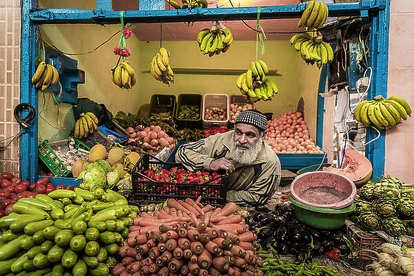 Vendor at fruit and vegetable stall in market in the medina (old city), Essaouira, Morocco