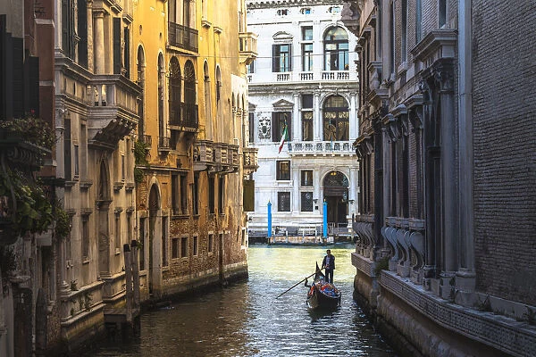 Venice, Veneto, Italy. Gondola rowing among historical palaces