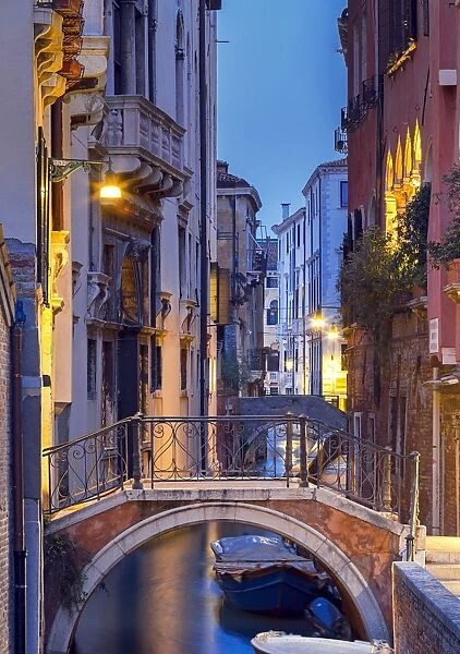 Venice, Veneto, Italy. View over a bridge and a canal at dusk