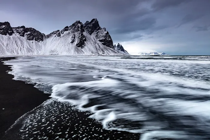 Framed Print : Vestrahorn mountain in winter, with waves washing up the black sand beach. Stokksnes, Southeast Iceland