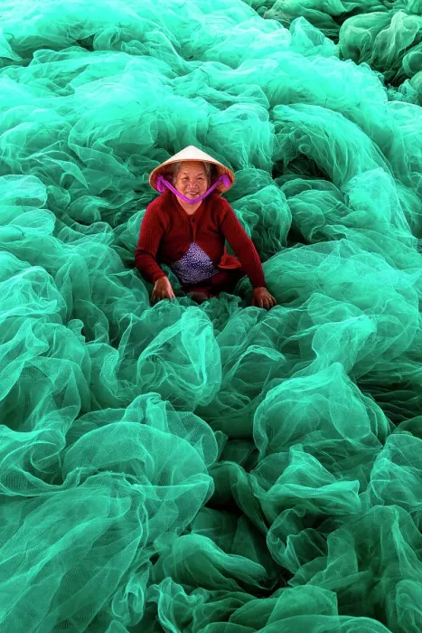 Framed Print : Vietnam, Cam Rahn, a woman mends green fishing nets