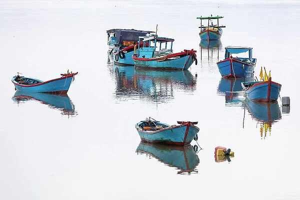 Vietnam, Cam Ranh, traditional fishing boats reflected in calm water