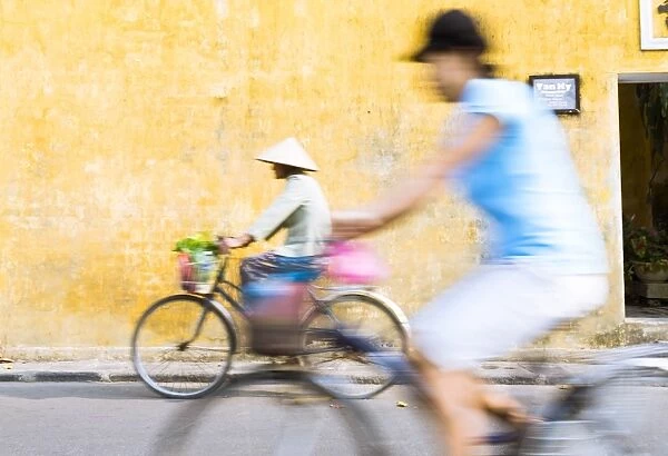 Vietnam, Hoi An. Local people on bicycle in the streets of the town