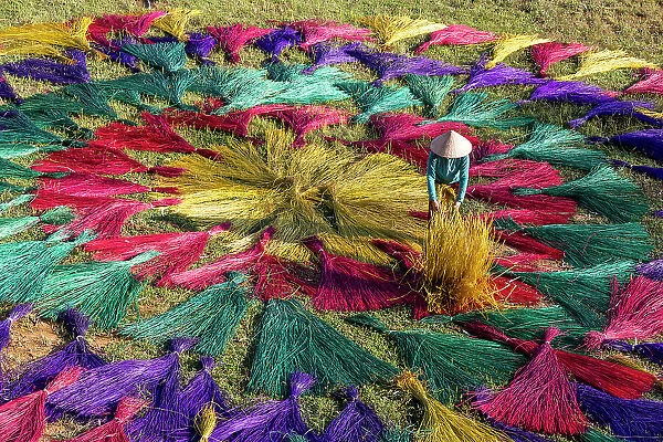Vietnam, Phu Yen province, a woman lays out traditional reed mats to dry