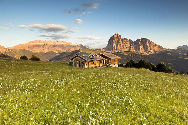 a view of an alpine hut during a sunset in Val Gardena with the Sella Group and the